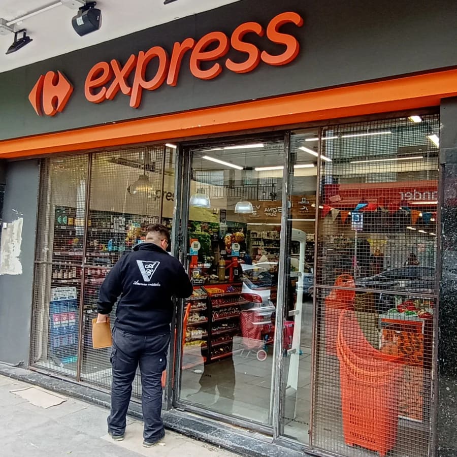 Colocador de Amorena trabajando en la puerta de un Carrefour Express